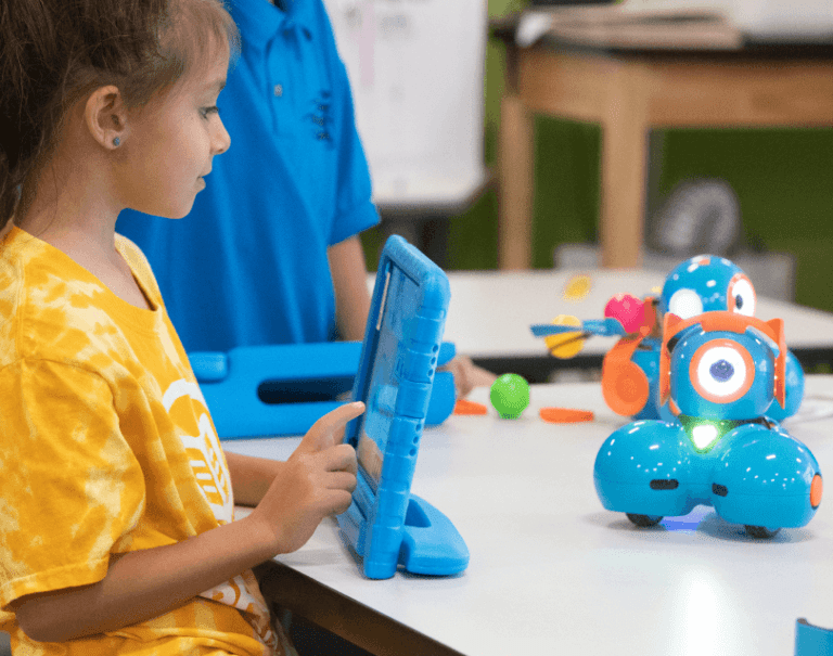 girl learning to play with a robot on table